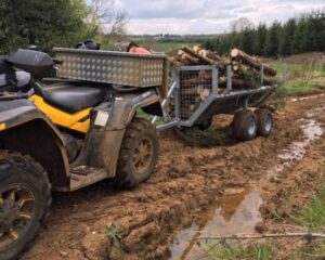 atv log trailer travels through muddy terrain easily