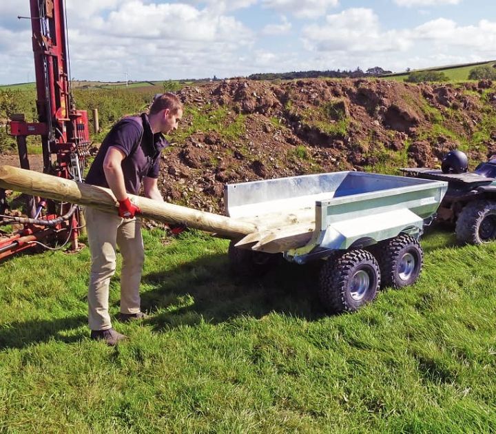Chapman ATV hydraulic tipping trailer transporting large wooden posts